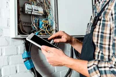 side view of installer holding slip joint pliers near pipe and touching faucet in bathroom