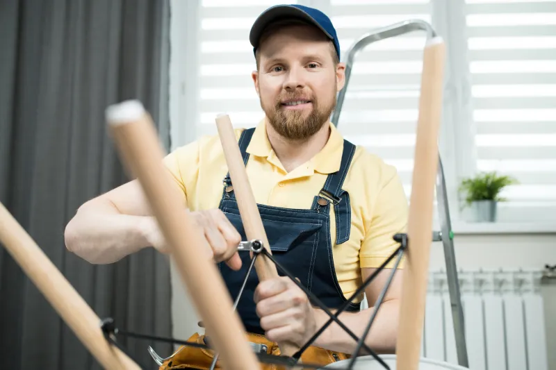 Smiling handyman screwing bolt of stool