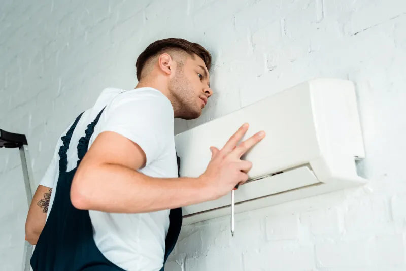 Worker installing air conditioner